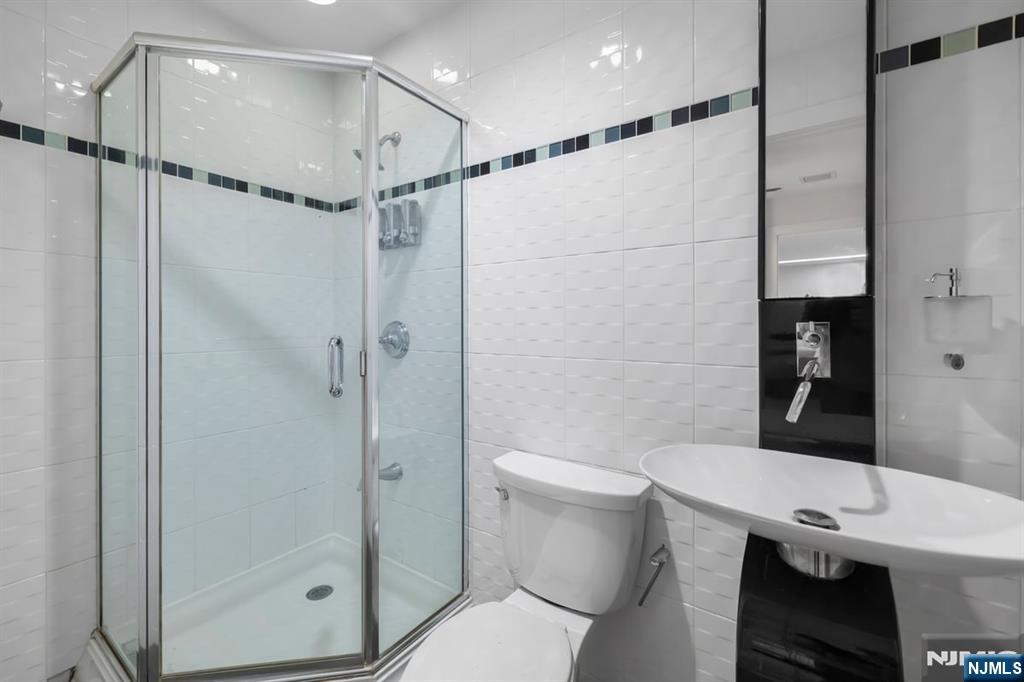 827 Alden Road Paramus, NJ 07652 - Photo 13 of 43 a bathroom with a shower a toilet and sink