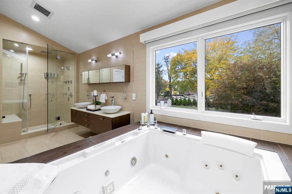 827 Alden Road Paramus, NJ 07652 - Photo 19 of 43 a spacious bathroom with a tub sink shower and mirror