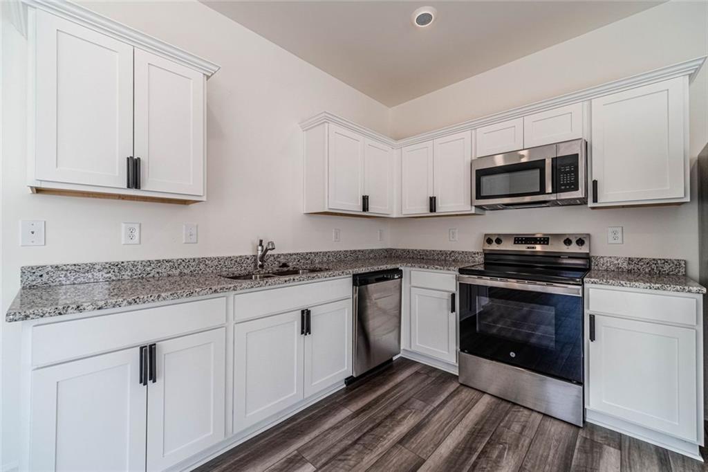 29 Padley Drive Winder, GA 30680 - Photo 7 of 25 a kitchen with granite countertop a sink and a stove top oven