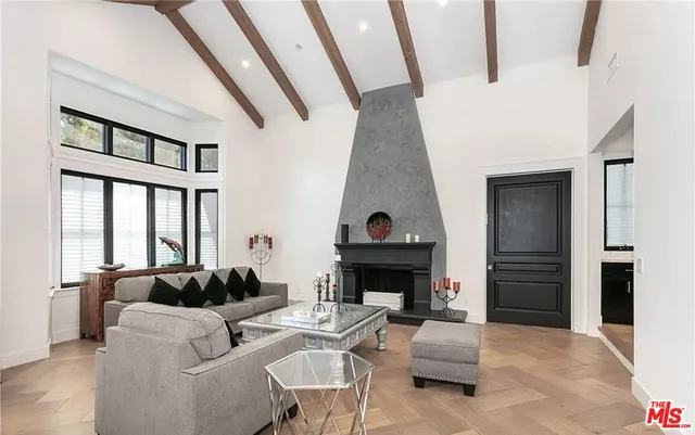 a living room with furniture a fireplace and a large window