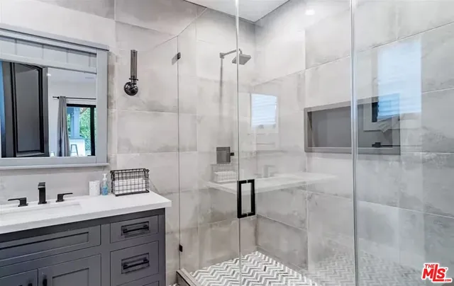 a bathroom with a sink a toilet a mirror and shower