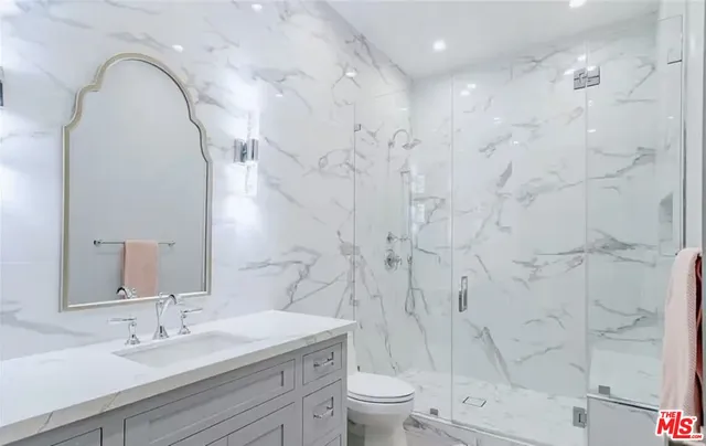 a spacious bathroom with a sink a toilet and a mirror