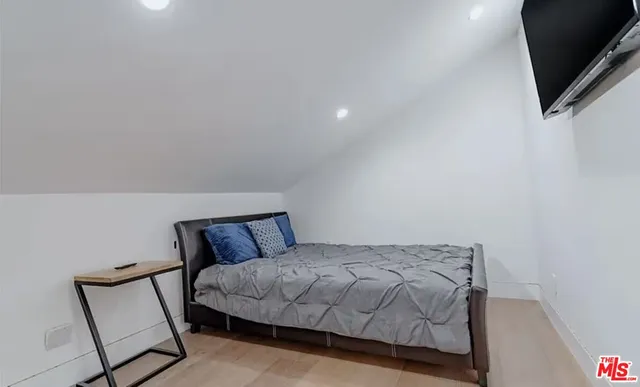 a bedroom with a bed and flat screen tv