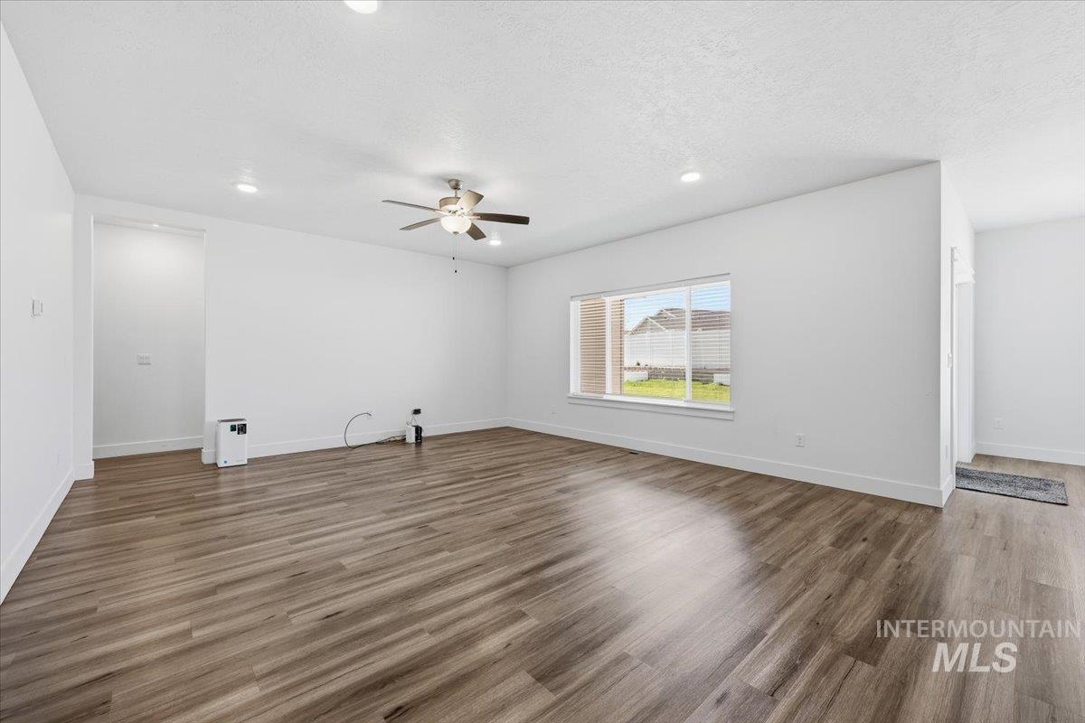 148 Homesteaders Street Middleton, ID 83644 - Photo 17 of 45 Unfurnished living room featuring recessed lighting, dark wood-type flooring, a ceiling fan, and a textured ceiling