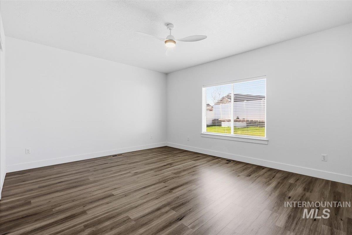 148 Homesteaders Street Middleton, ID 83644 - Photo 20 of 45 Unfurnished room featuring a ceiling fan, dark wood-style flooring, and a textured ceiling