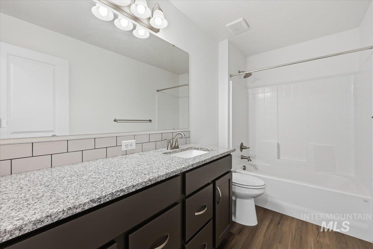 148 Homesteaders Street Middleton, ID 83644 - Photo 31 of 45 Bathroom featuring vanity, dark wood finished floors, and bathtub / shower combination