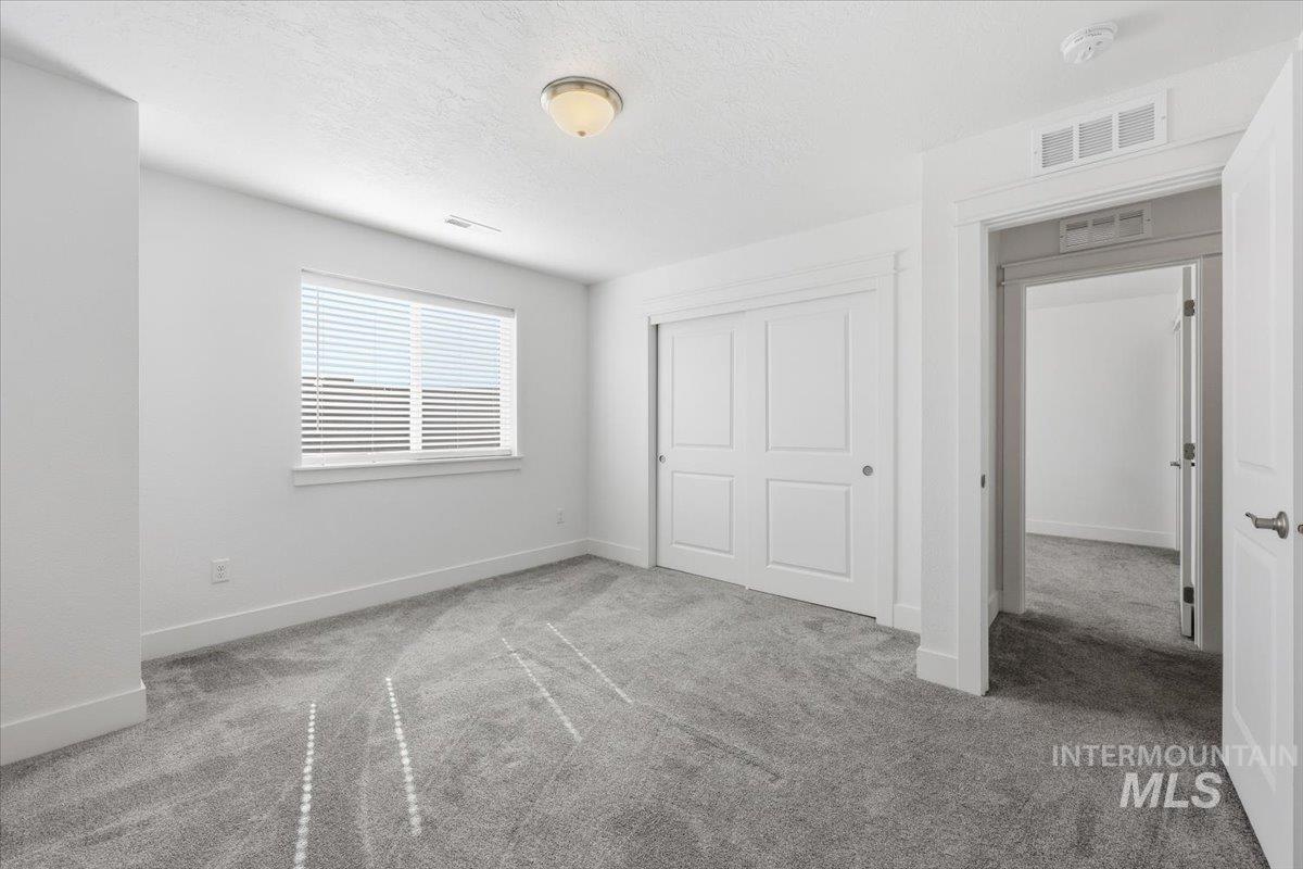 148 Homesteaders Street Middleton, ID 83644 - Photo 32 of 45 Unfurnished bedroom with carpet, a textured ceiling, and a closet