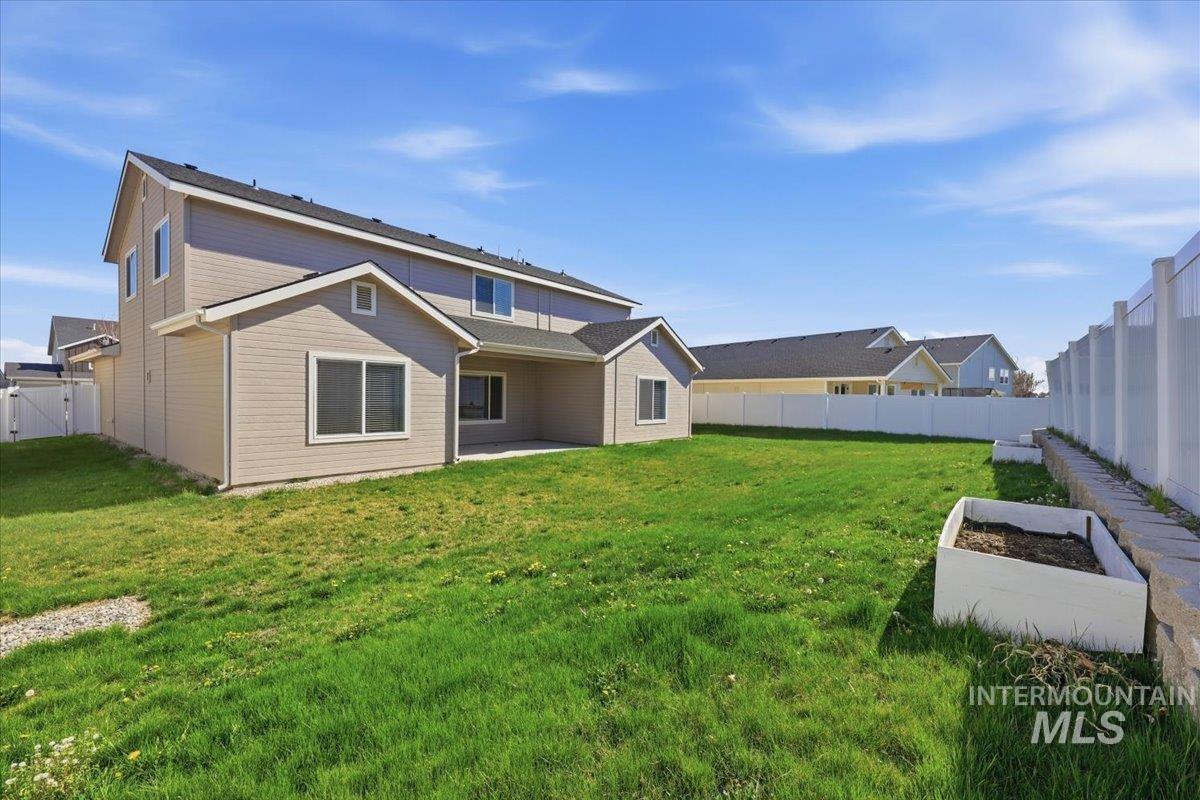 148 Homesteaders Street Middleton, ID 83644 - Photo 39 of 45 Rear view of house with a patio area, a fenced backyard, a garden, and a gate