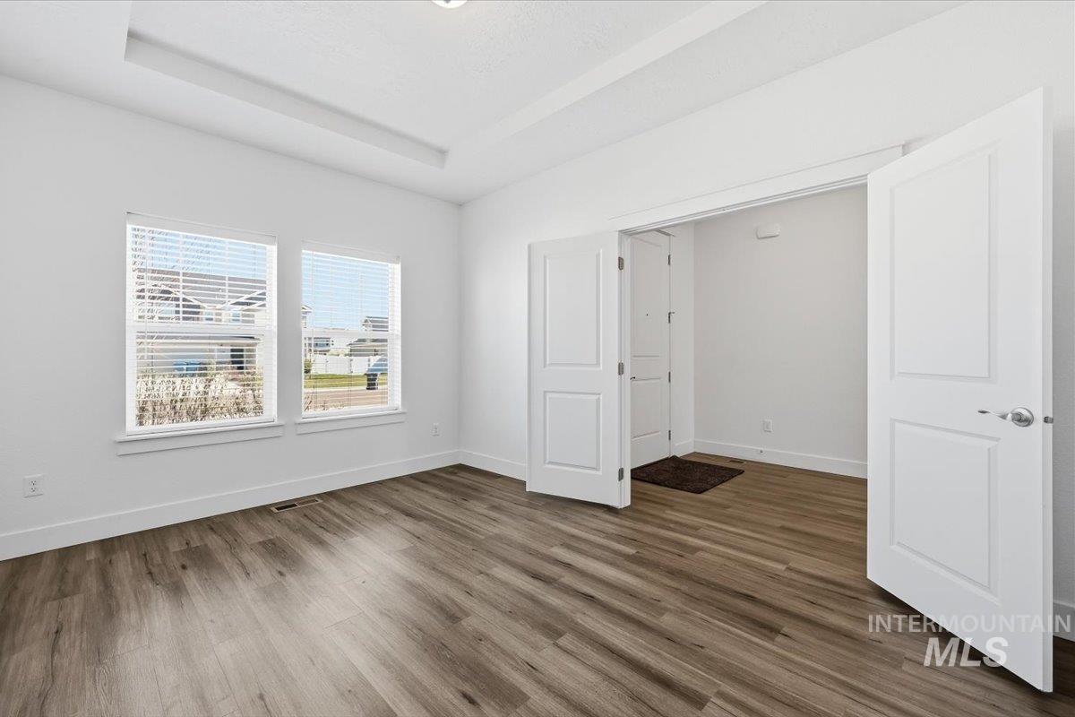 148 Homesteaders Street Middleton, ID 83644 - Photo 5 of 45 Unfurnished bedroom featuring dark wood-style flooring and a raised ceiling