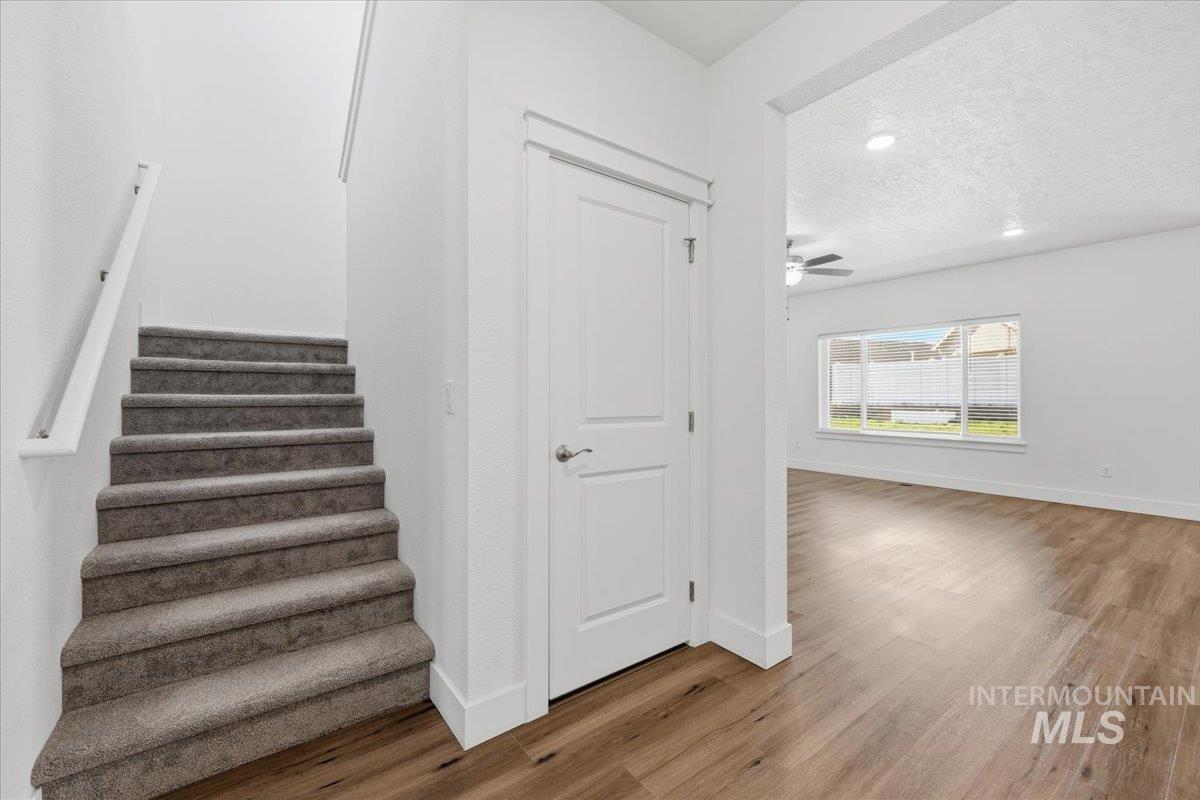 148 Homesteaders Street Middleton, ID 83644 - Photo 6 of 45 Stairway with wood finished floors, recessed lighting, a textured ceiling, and ceiling fan