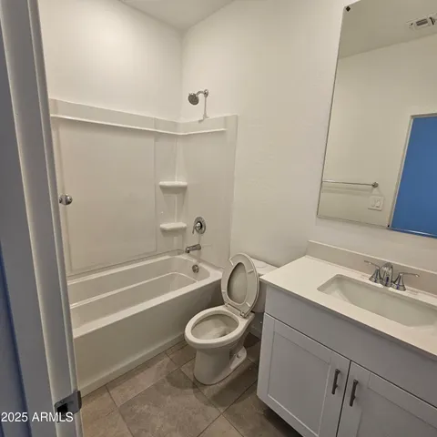 a bathroom with a sink a toilet a mirror and shower