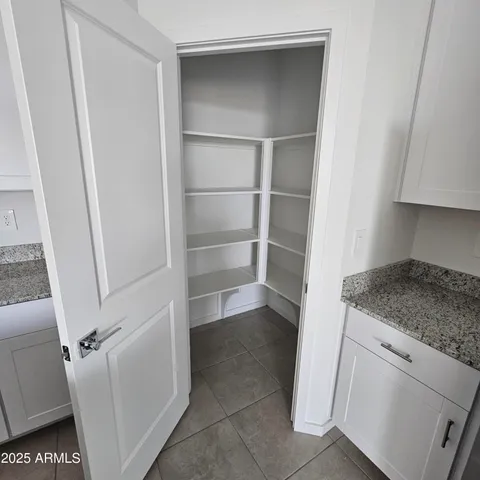 a view of a kitchen with refrigerator and white cabinets