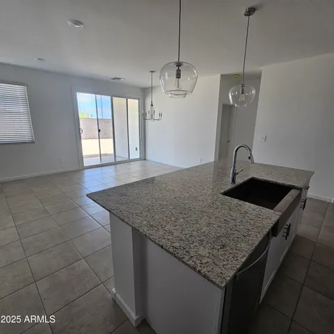 a kitchen with granite countertop a sink a counter top space and cabinets