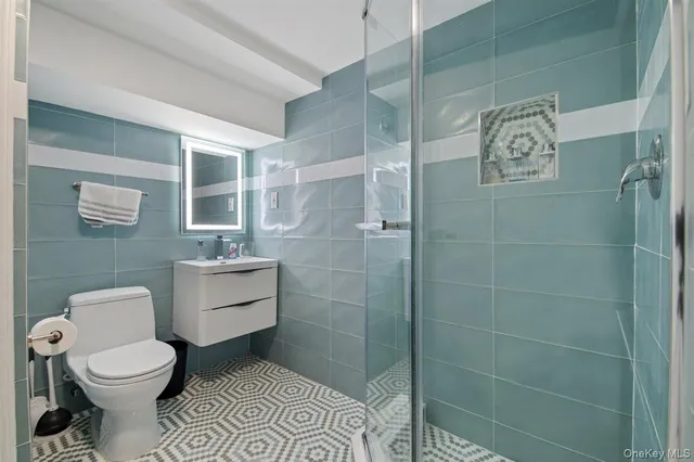 a bathroom with a toilet a sink and shower