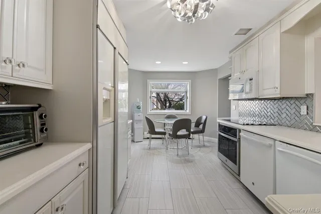 a kitchen with granite countertop cabinets stainless steel appliances a sink and a dining table view