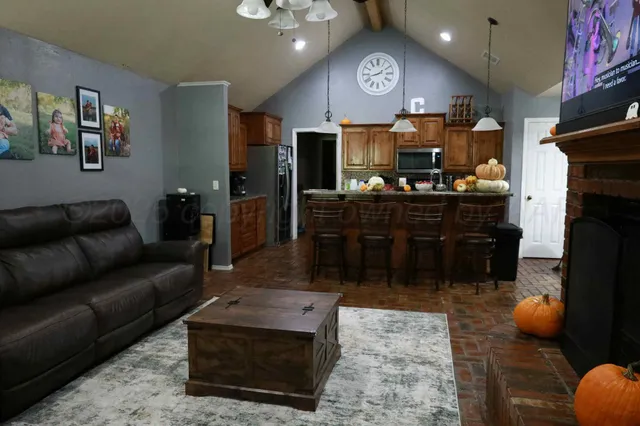 a living room with furniture a kitchen and a fireplace
