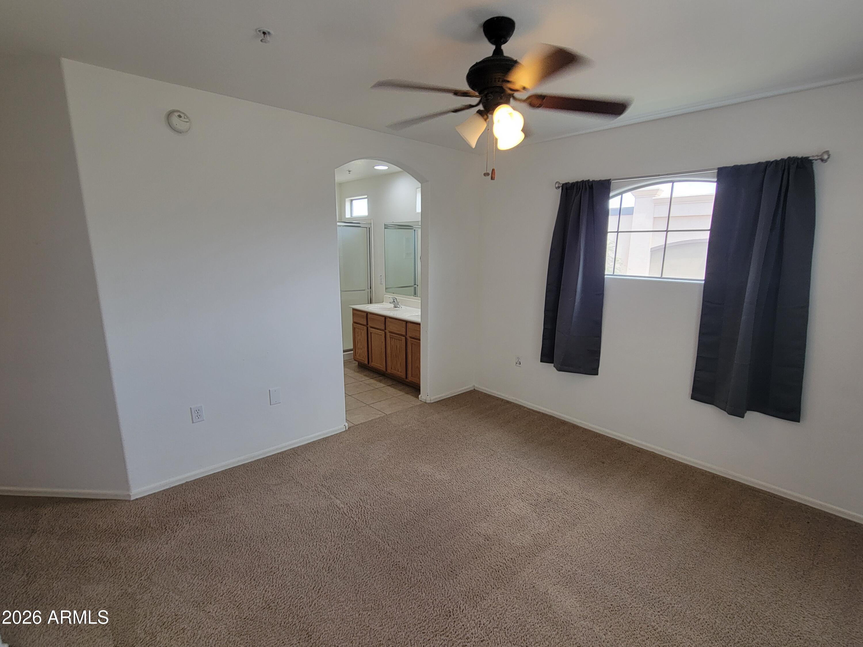 1350 South Greenfield Road, Unit 1053 Mesa, AZ 85206 - Photo 12 of 25 an empty room with windows and fan