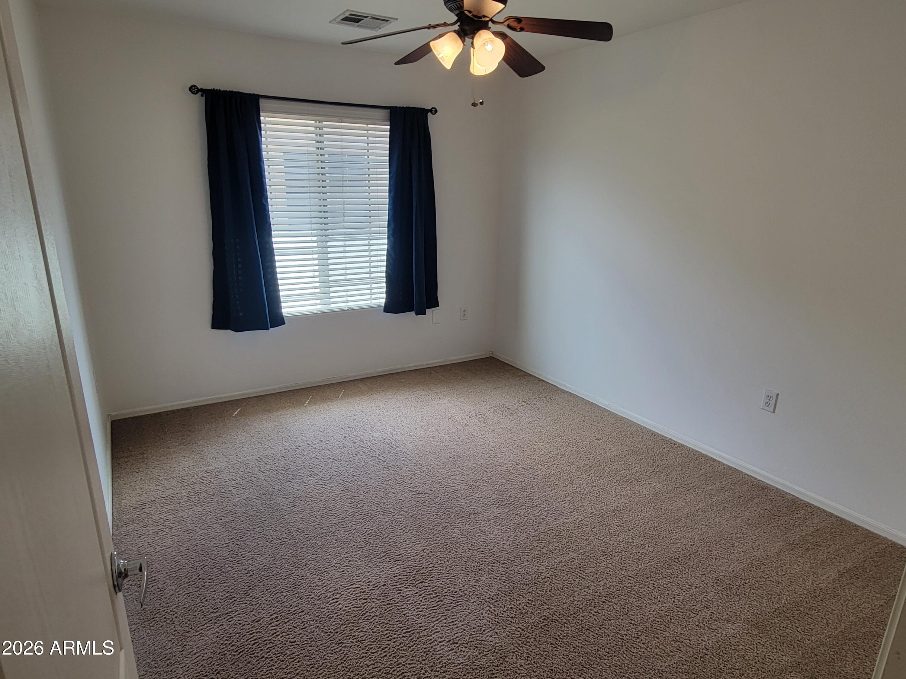1350 South Greenfield Road, Unit 1053 Mesa, AZ 85206 - Photo 14 of 25 an empty room with windows and fan