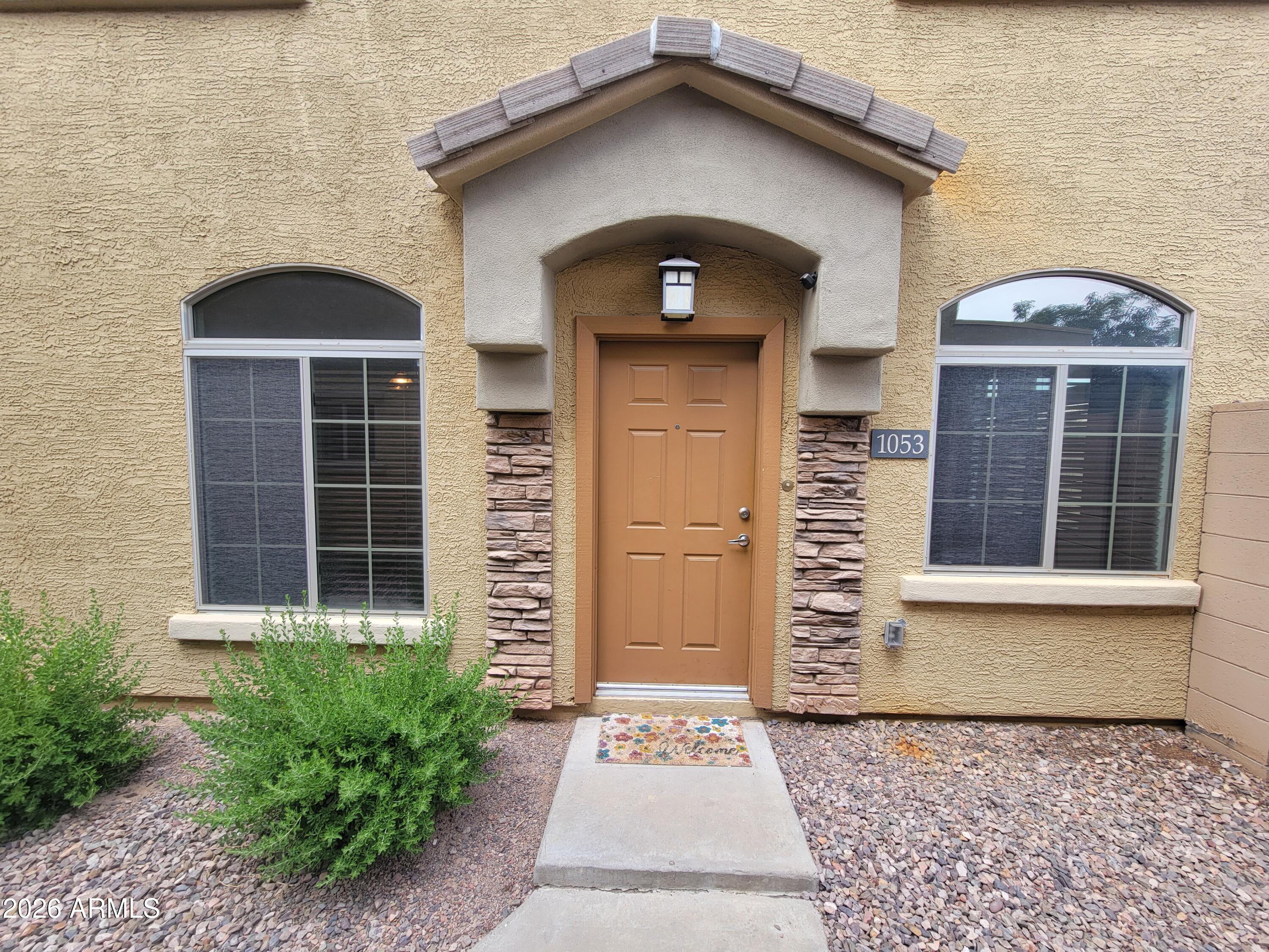 1350 South Greenfield Road, Unit 1053 Mesa, AZ 85206 - Photo 2 of 25 a front view of a house with a yard
