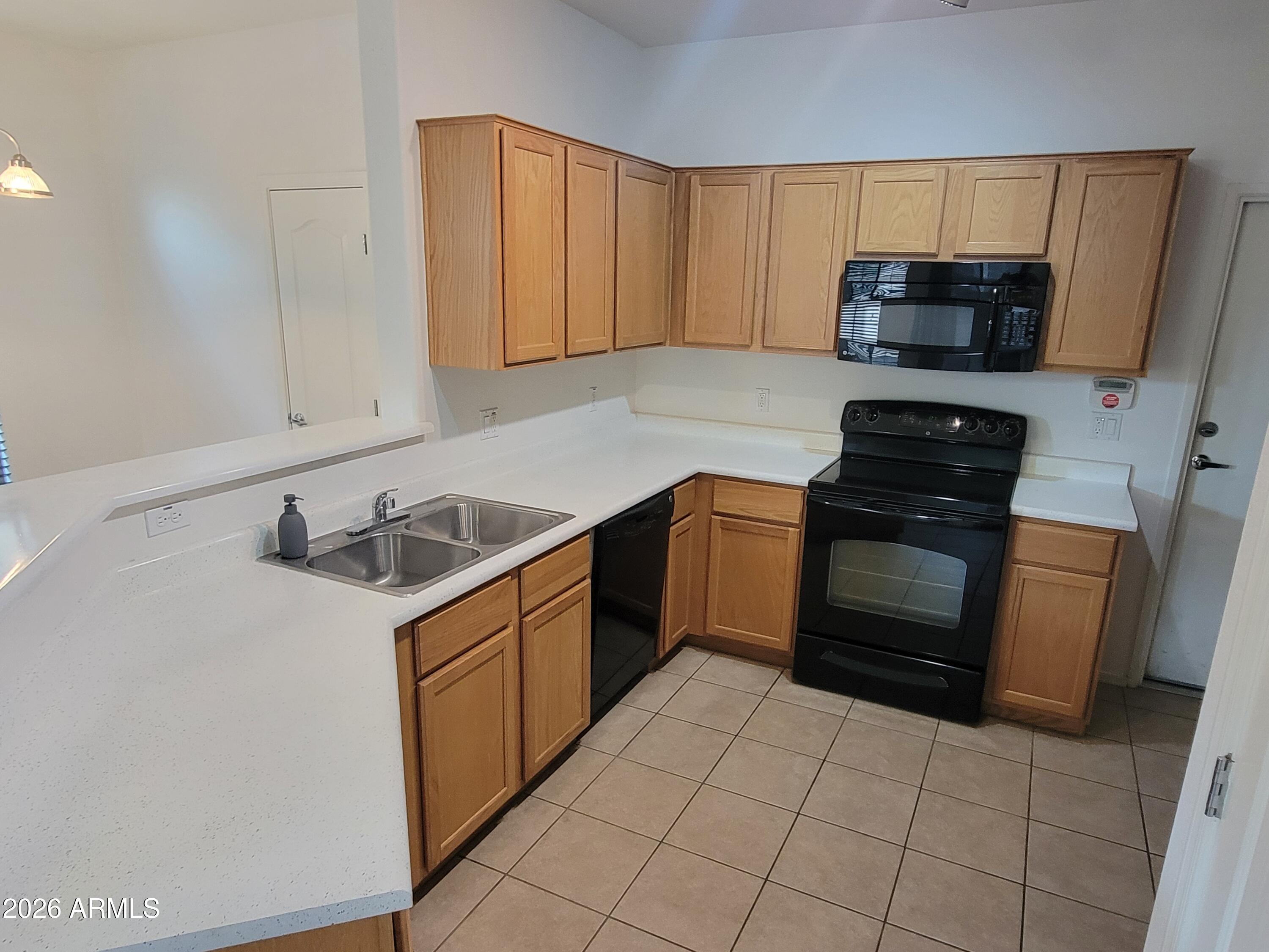 1350 South Greenfield Road, Unit 1053 Mesa, AZ 85206 - Photo 4 of 25 a kitchen with a stove sink and microwave