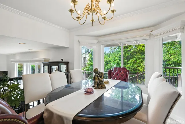 a view of a dining room with furniture large windows and wooden floor