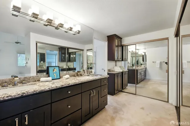a bathroom with a granite countertop sink mirror and shower