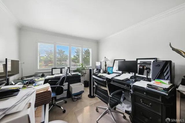 a view of a workspace with furniture and a window
