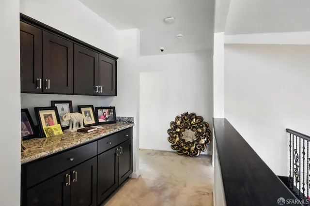 a kitchen with granite countertop a refrigerator and a stove top oven