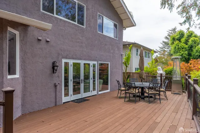 a view of a patio with table and chairs and wooden floor