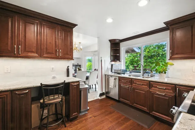 a kitchen with stainless steel appliances granite countertop a sink stove and cabinets