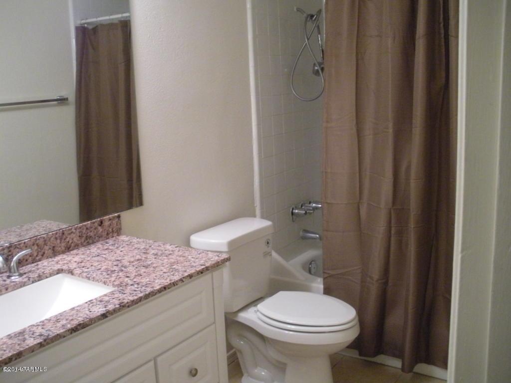 1600 North Wilmot Road, Unit 245 Tucson, AZ 85712 - Photo 5 of 12 a bathroom with a granite countertop sink and a toilet