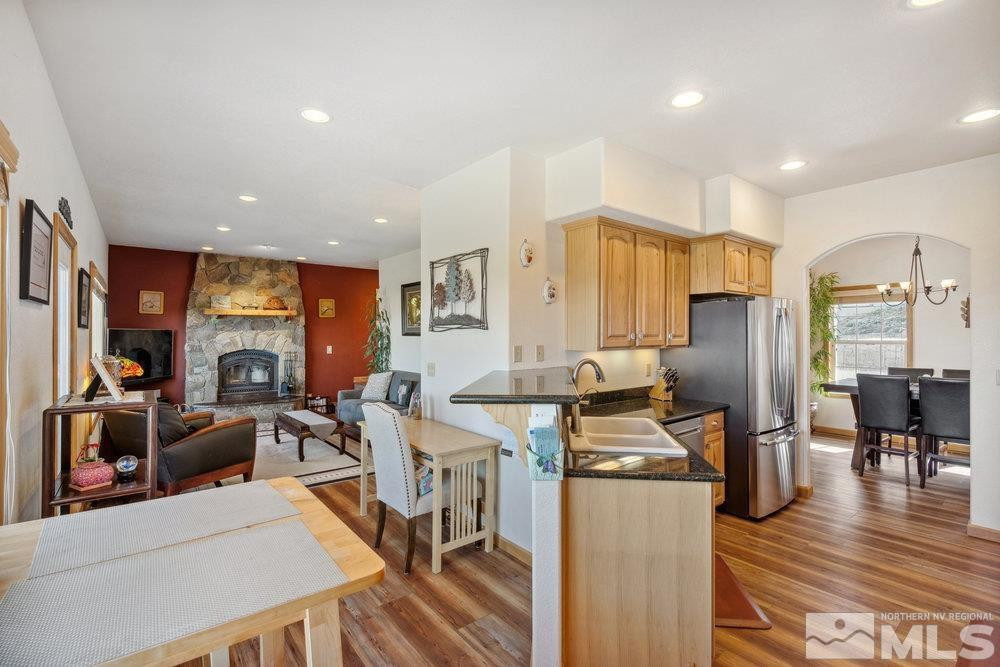 2045 Flint Road Reno, NV 89521 - Photo 7 of 33 a kitchen with stainless steel appliances kitchen island granite countertop a refrigerator a stove and a dining table with wooden floor