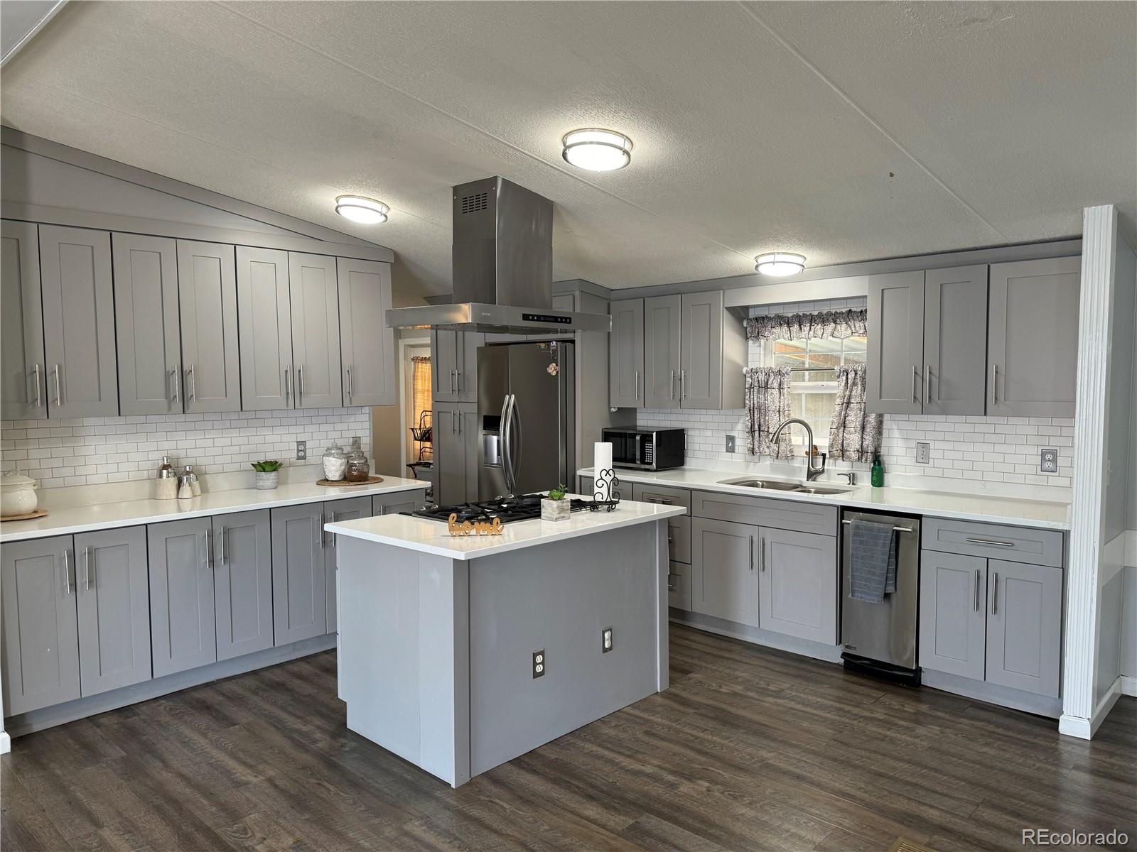1921 Quintero Street Aurora, CO 80011 - Photo 1 of 18 a kitchen with kitchen island granite countertop wooden cabinets and white appliances