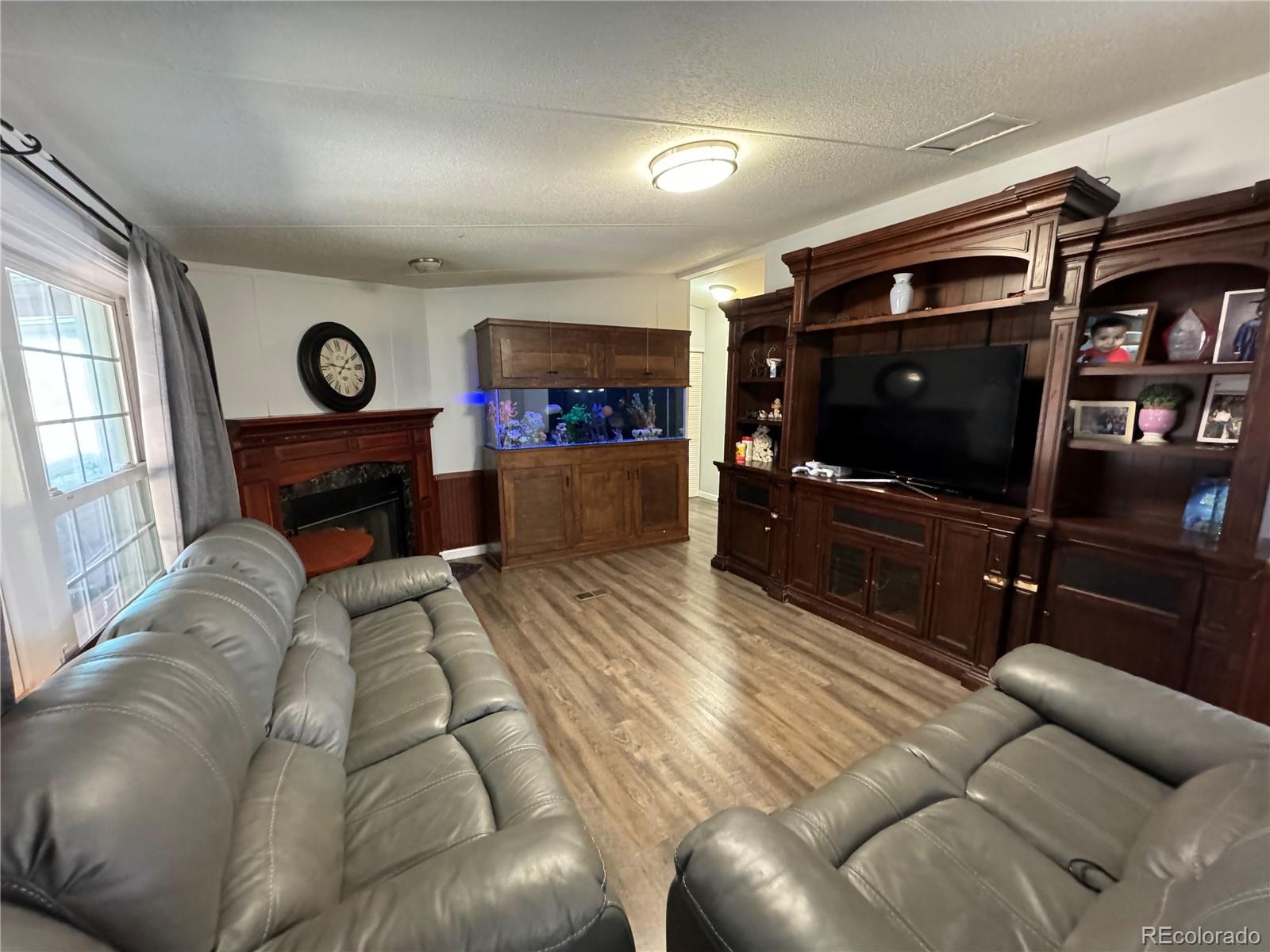 1921 Quintero Street Aurora, CO 80011 - Photo 12 of 18 a living room with furniture a flat screen tv and a fireplace