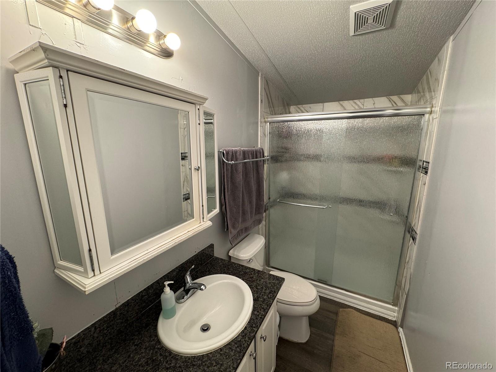 1921 Quintero Street Aurora, CO 80011 - Photo 14 of 18 a bathroom with a sink a toilet and shower