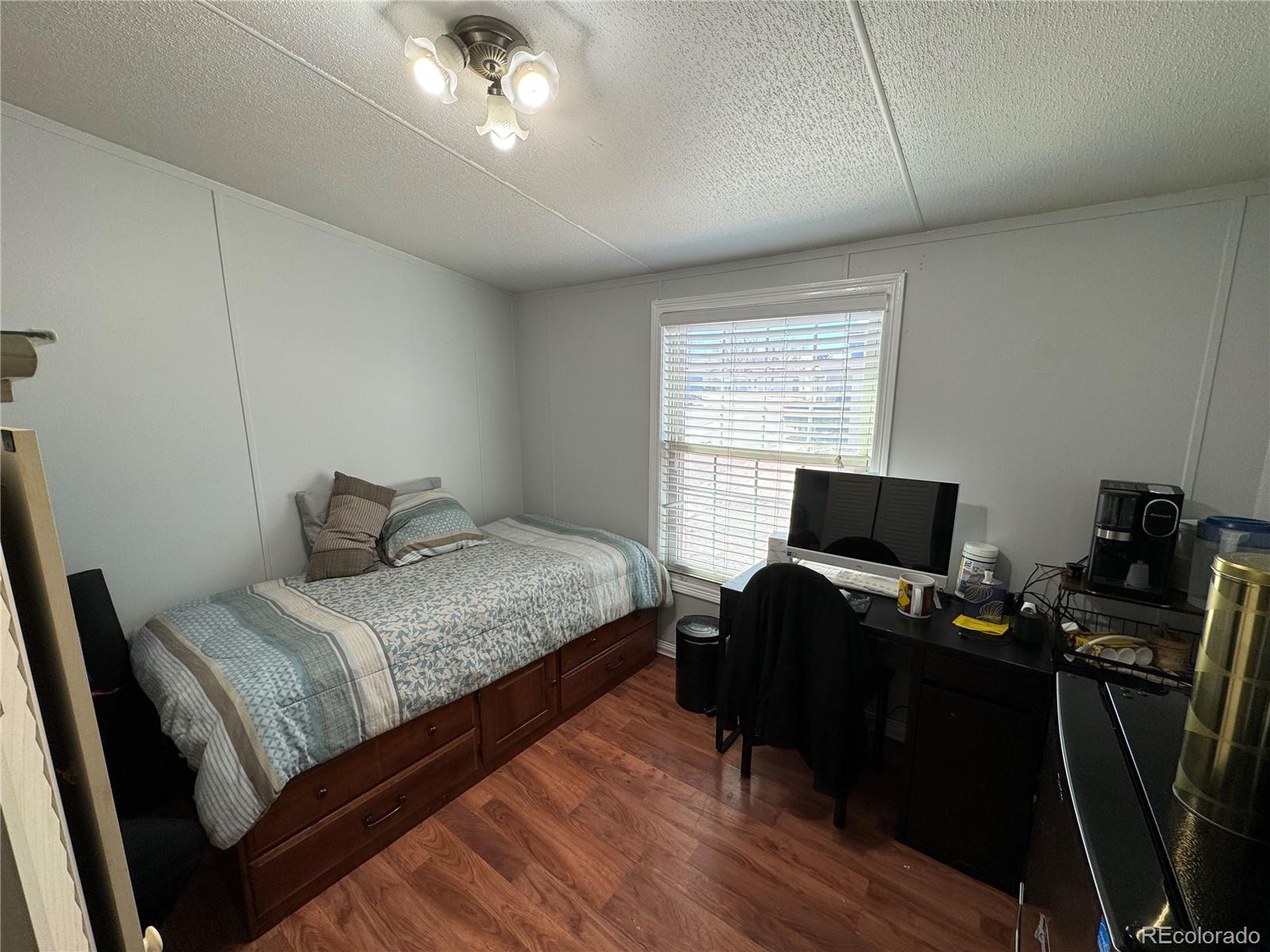 1921 Quintero Street Aurora, CO 80011 - Photo 15 of 18 a bedroom with a bed and a flat screen tv