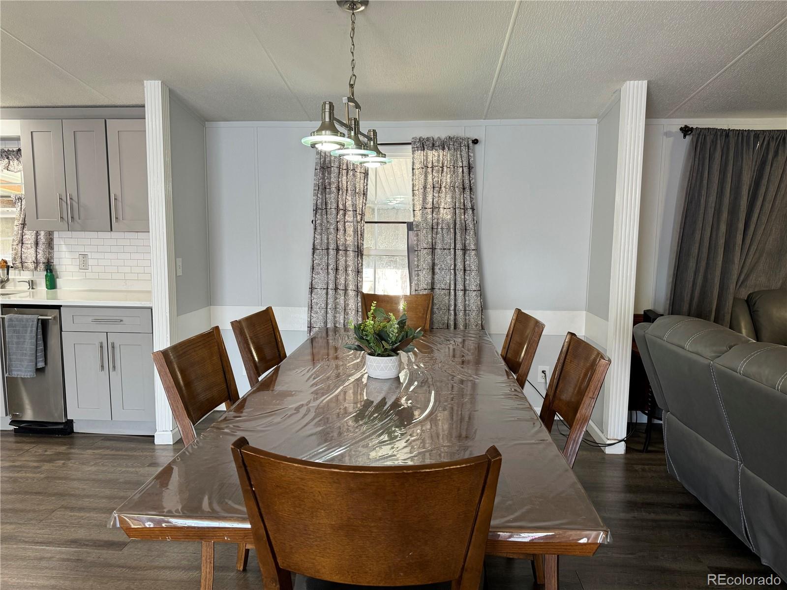 1921 Quintero Street Aurora, CO 80011 - Photo 2 of 18 a living room with furniture and a chandelier