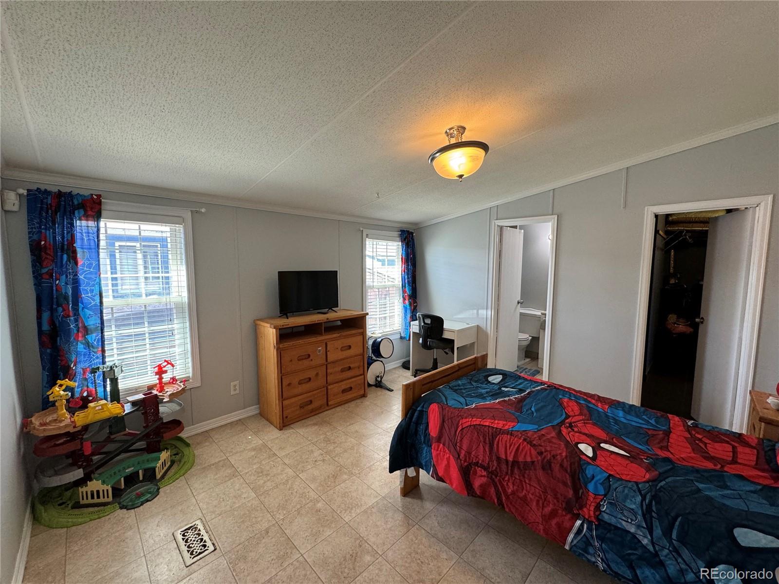 1921 Quintero Street Aurora, CO 80011 - Photo 7 of 18 a bedroom with bed and a window