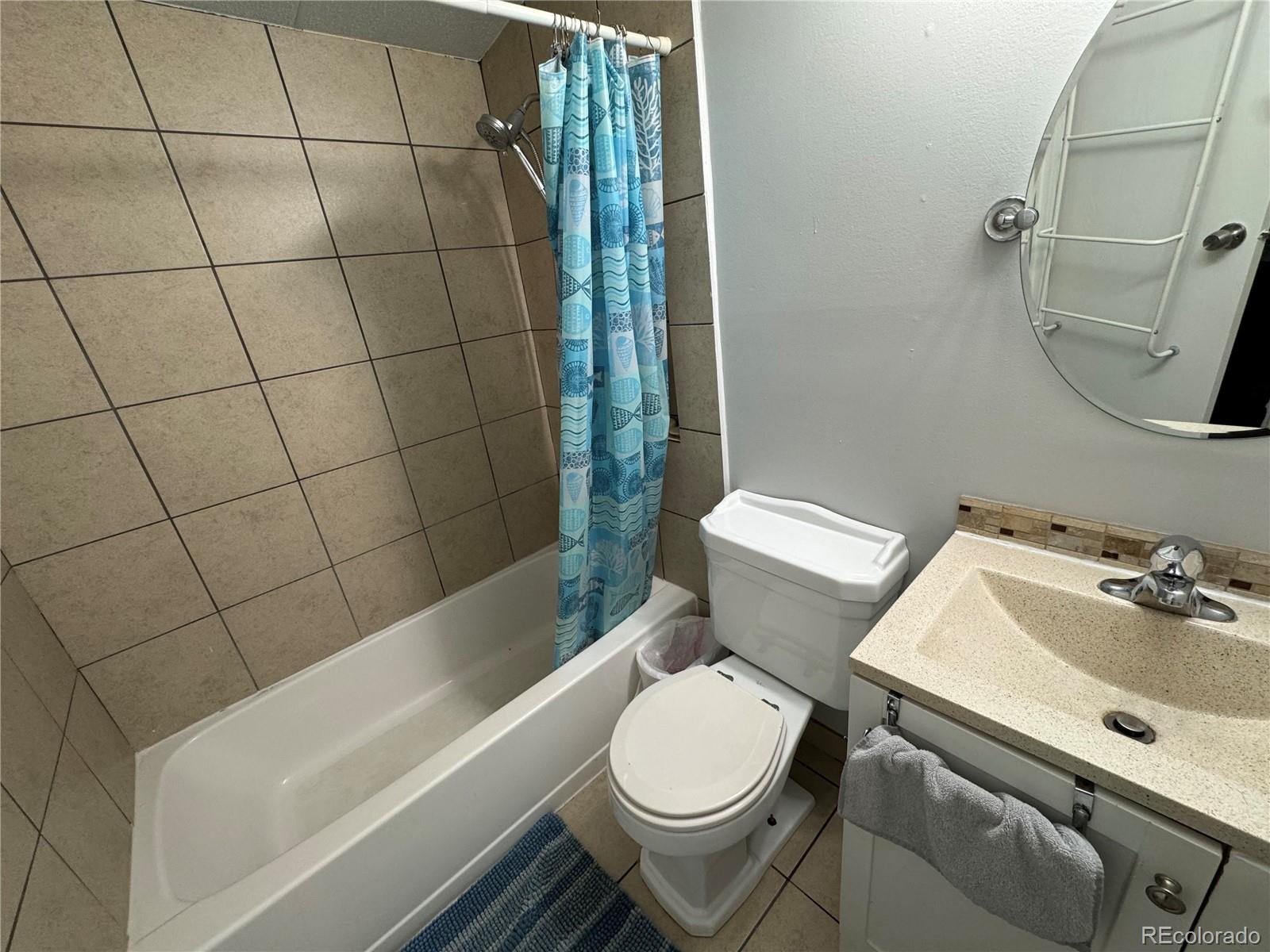 1921 Quintero Street Aurora, CO 80011 - Photo 8 of 18 a bathroom with a sink toilet and shower