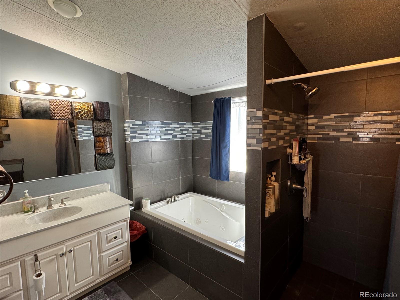 1921 Quintero Street Aurora, CO 80011 - Photo 10 of 18 a bathroom with a sink and a mirror