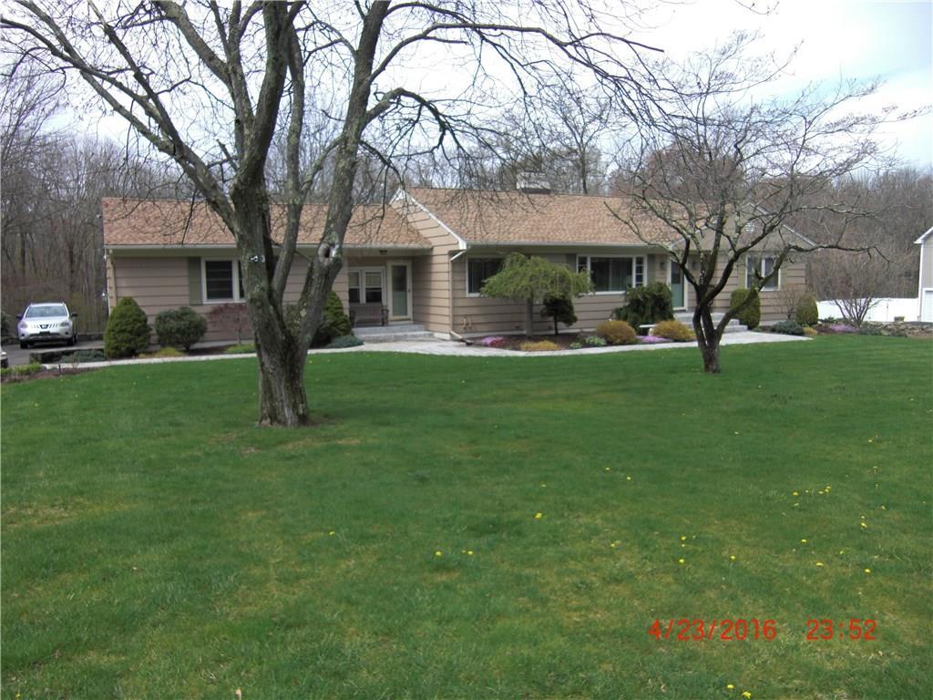 606 Racebrook Road Orange, CT 06477 - Photo 1 of 1 a front view of a house with a garden and trees