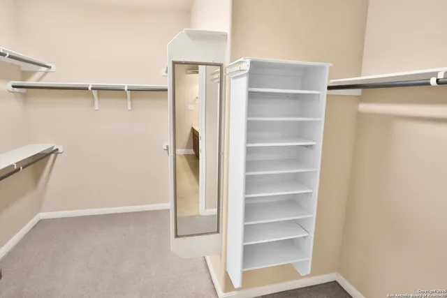 a view of walk in closet with empty racks