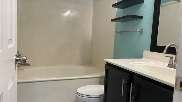a bathroom with a granite countertop sink toilet and bathtub