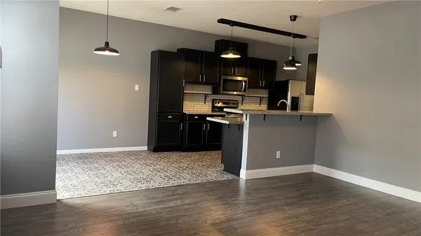 a kitchen with a refrigerator and a stove top oven