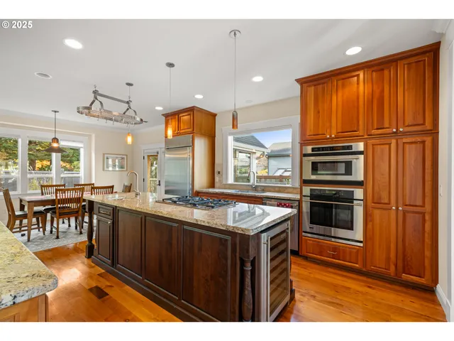a kitchen with stainless steel appliances granite countertop a sink a stove and a refrigerator