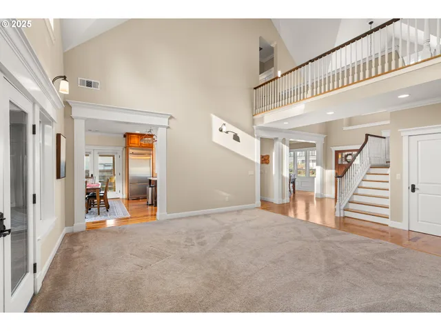 a dining room with wooden floor a chandelier a glass table and chairs