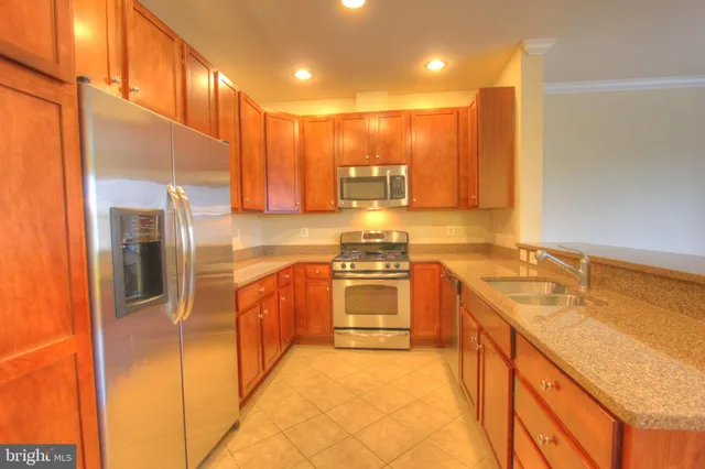 a large kitchen with stainless steel appliances granite countertop a sink and cabinets