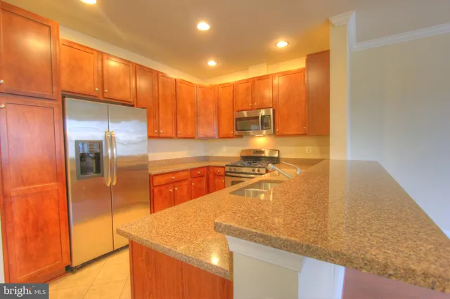 a kitchen with stainless steel appliances granite countertop a sink a stove and a refrigerator