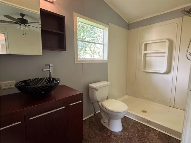 a bathroom with a granite countertop toilet a sink and a mirror
