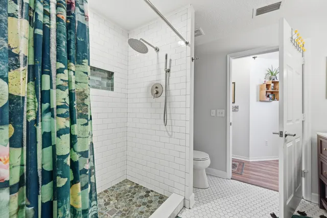 a view of a hallway with wooden floor and closet